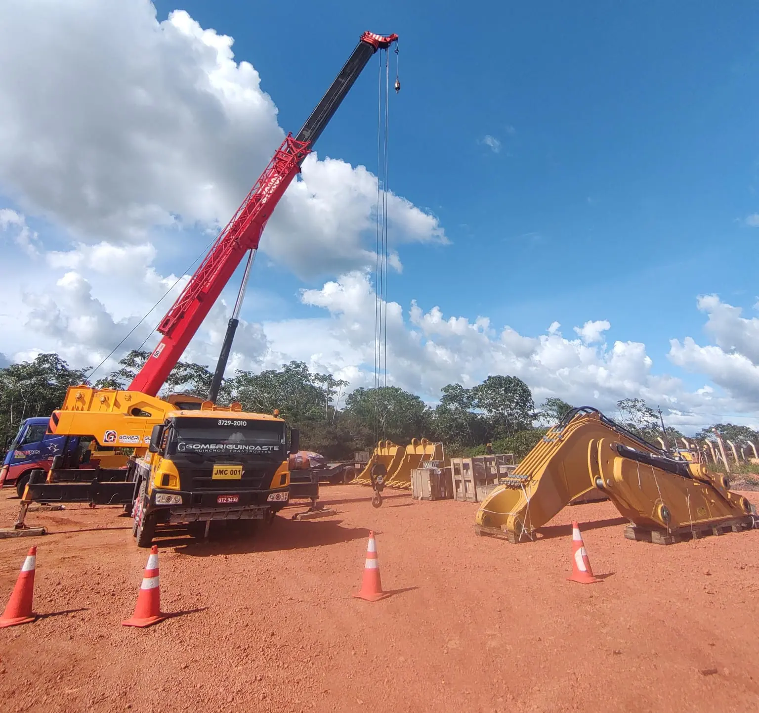 Gomeri mobile crane lifting an excavator at a job site