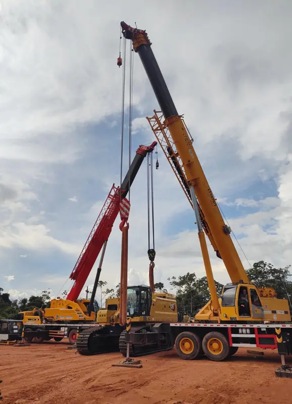 Two cranes with extended booms