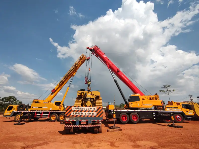 Two Gomeri truck-mounted cranes performing a tandem lift
